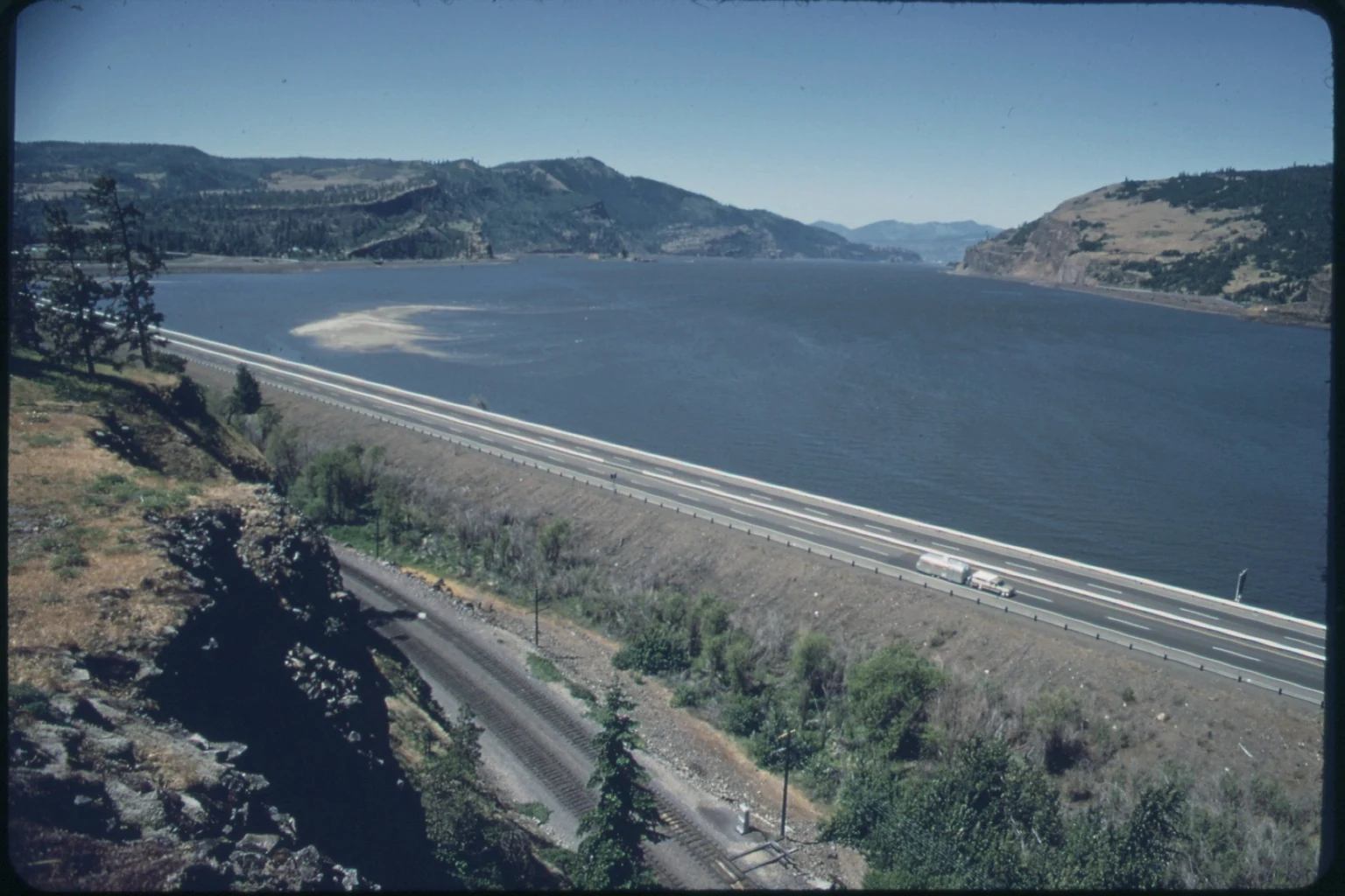 Columbia River Gorge in Oregon, a wide river running between dry canyon hills