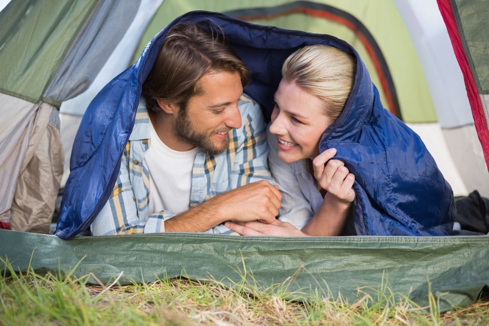 Couple snuggling under a sleeping bag