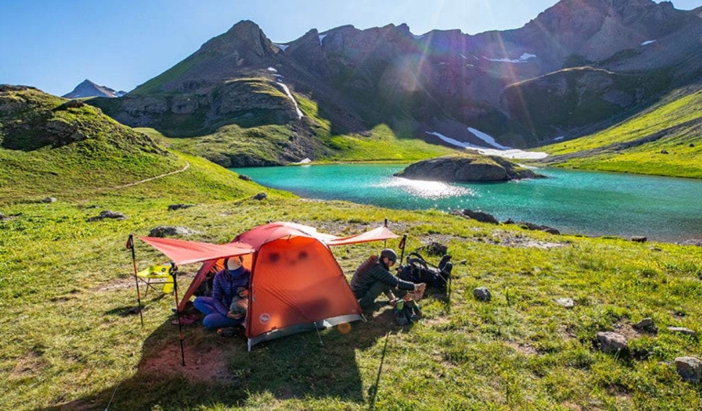 Beach camping tent with two people with mountain view