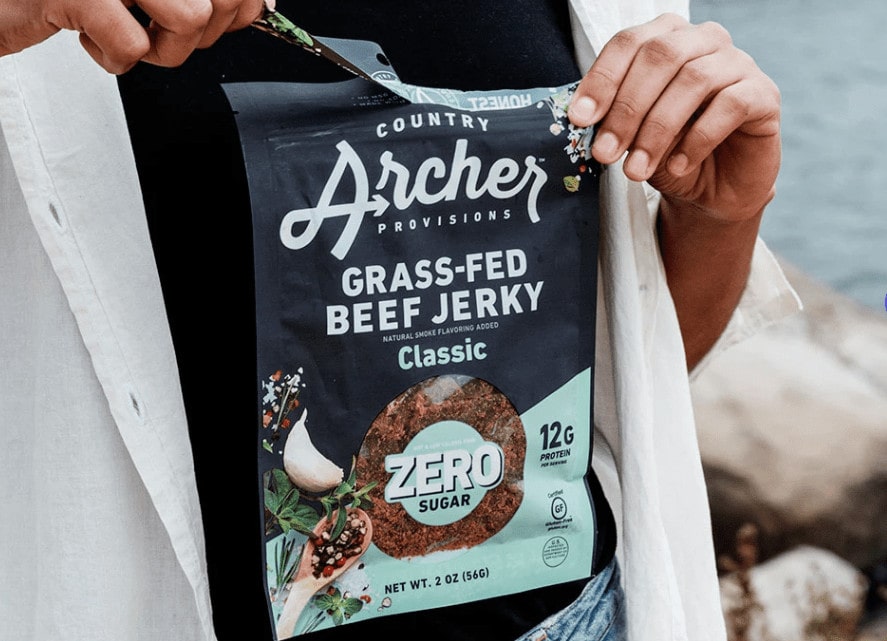 Woman holding a beef jerky pack for as her camping food