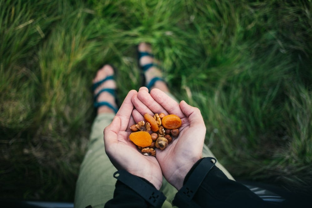 A person holding a trail mix snack as camping food