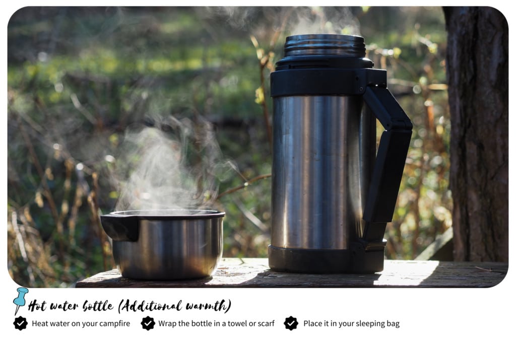 Camping thermos and a stainless pot with a boiling water on a table