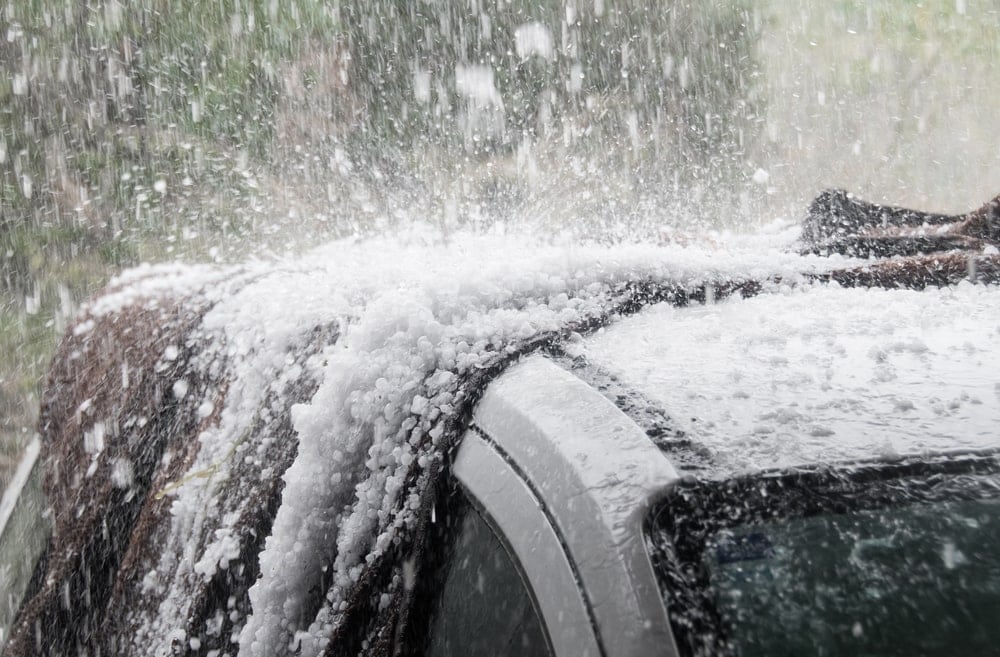 Hail stones pelting down on car roof during storm