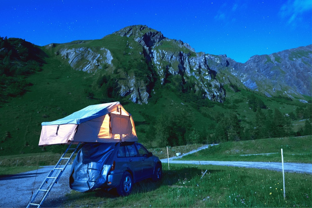 Car camping on fields with a mountain in front