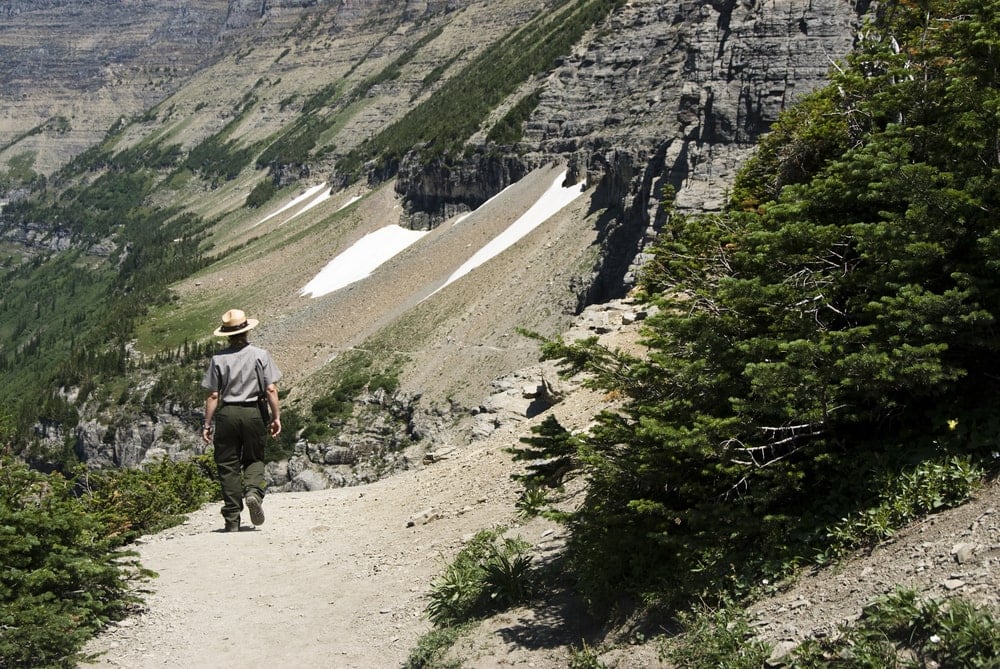 Park ranger walking on  Highline trail in Glacier National Park