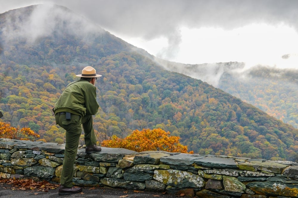 park ranger looking straight at mountainous view
