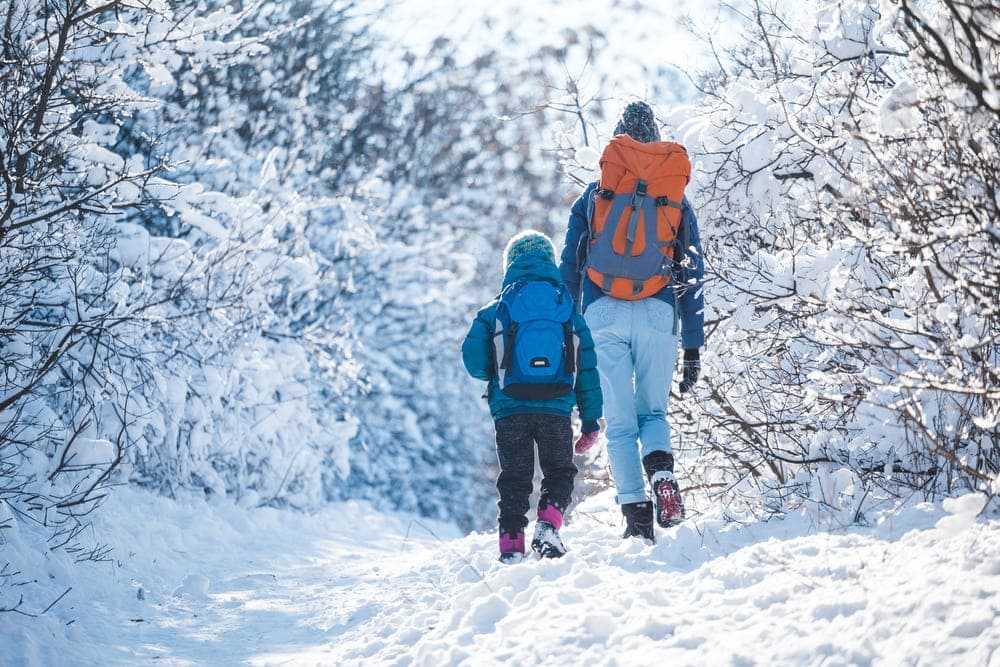 Woman and child hiking in winter