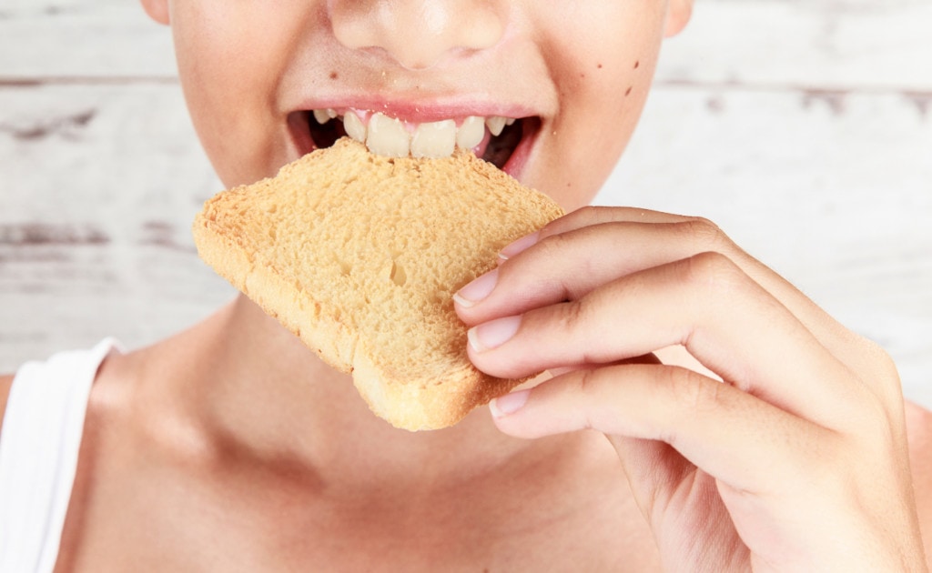 image of a woman biting on a toast of bread