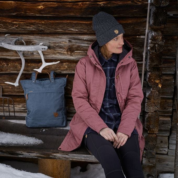 woman sitting on a bench wearing Fjällräven jacket
