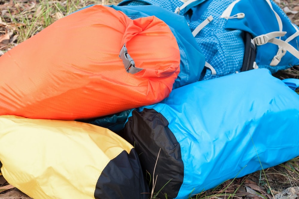 Different colors of backpacks laying on grass