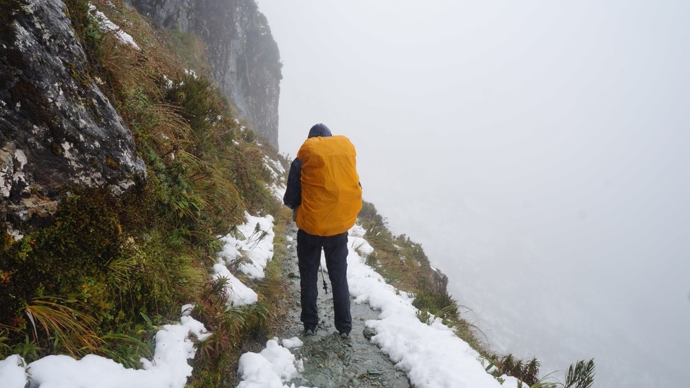 Guys hiking in snow with yellow backpack