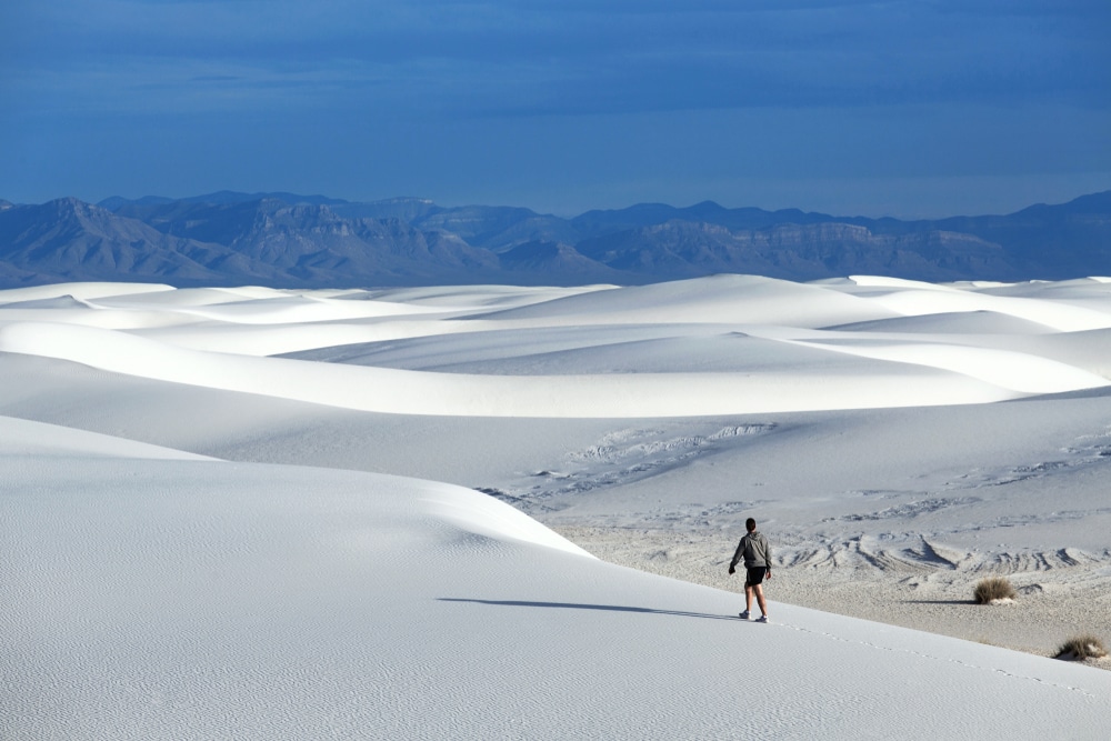 a hiker walks up in the white sand dunes national park in New Mexico, USA