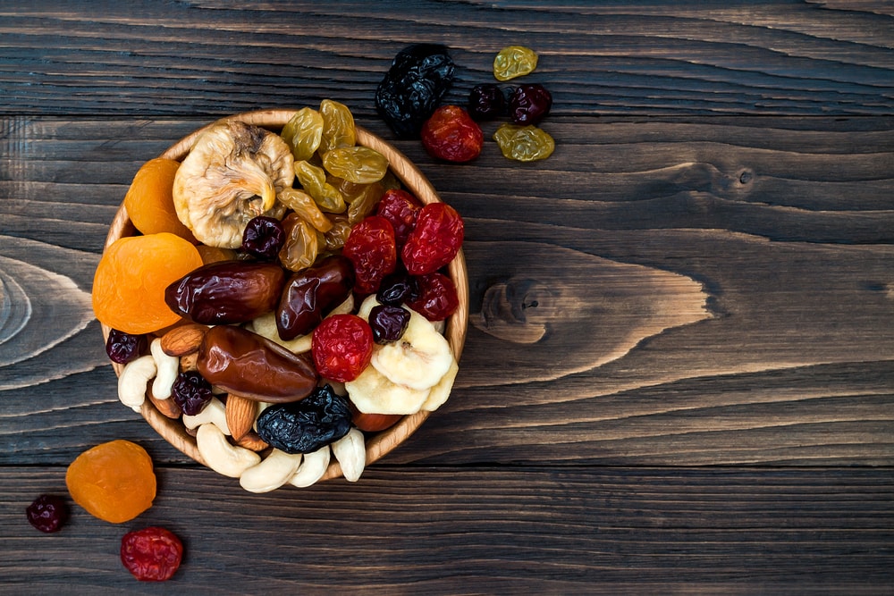 Mix of dried fruits and nuts on a dark wood