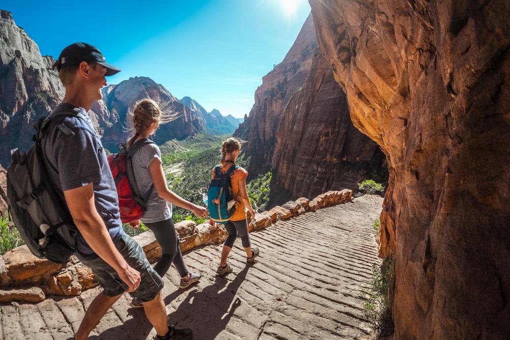 Group of hikers walking down the pathaway and enjoying view of Zion National Park, USA