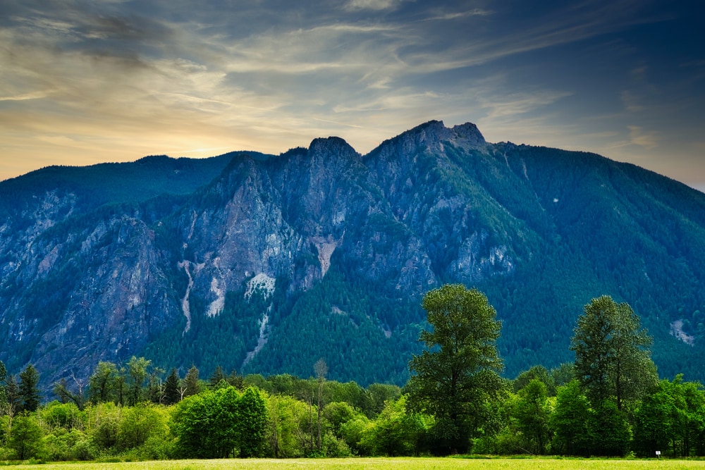 Mount Si in Washington with clear forest and swaying clouds on the background