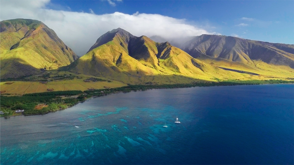 Aerial view of the west coast of Maui with visible coral reef and green mountain on the background. Area of Olowalu, Hawaii