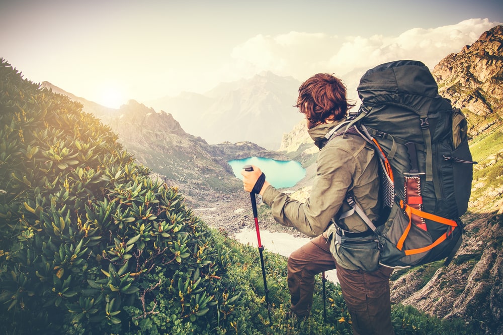 backpacking is one of the most common camping styles. A man with a camping backpack on a mountain trail