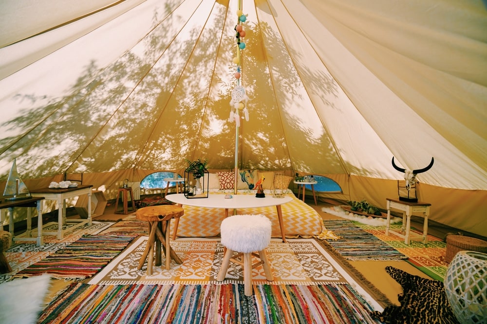 inside of a glamping tent with a cozy bed. glamping is a shortcut for glamorous camping