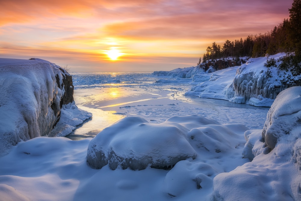 Frozen Lake Superior sunrise at Presque Isle Park, Winter in Marquette, Michigan.