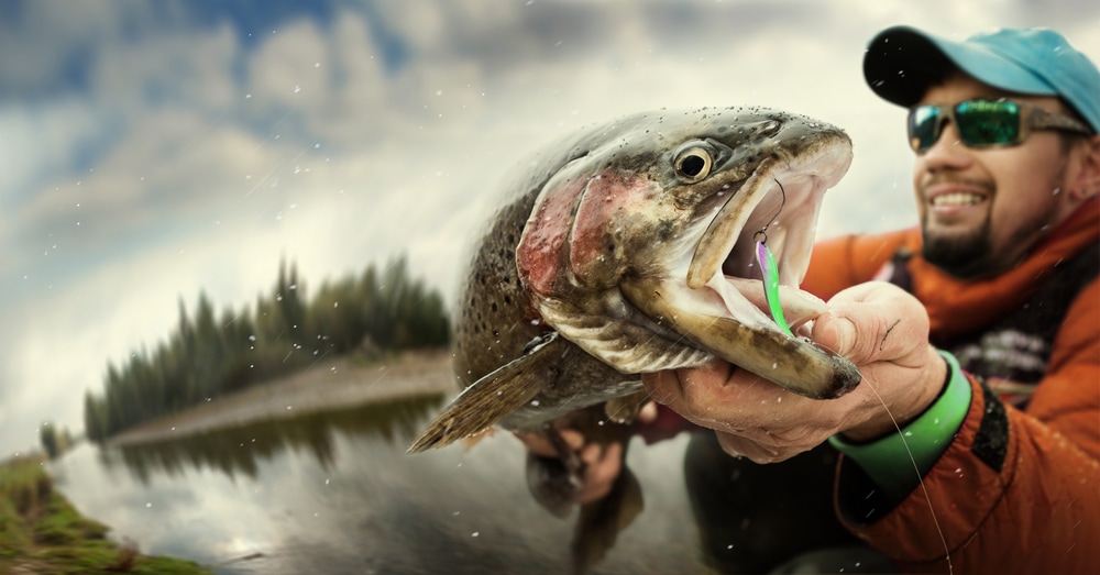image of a man showing a trout he caught 