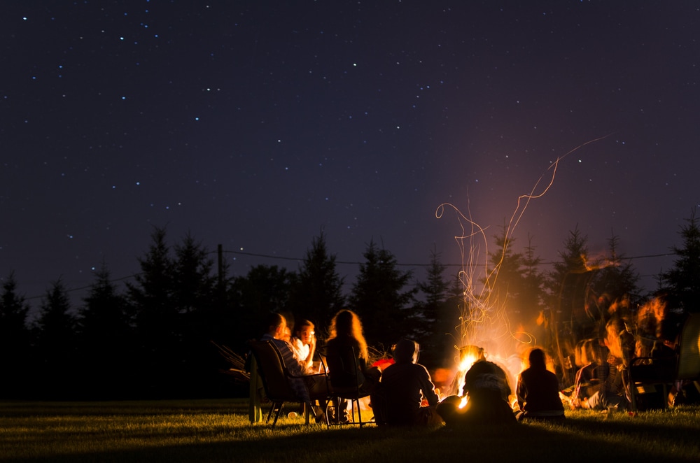 a group of friends enjoying a campfire in the wilderness