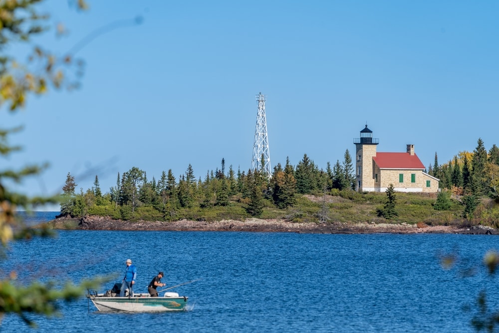 Copper Harbor Lighthouse on Lake Superior, with fishermen in a boat