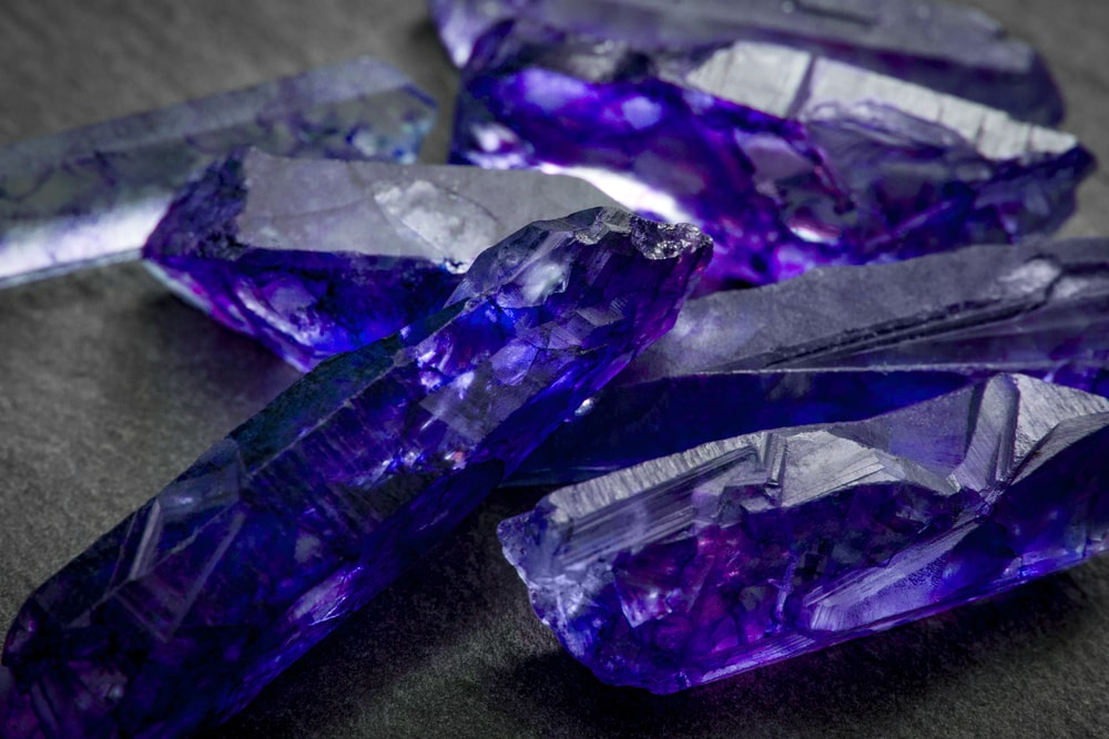 one of the rarest types of gems - the tanzanite showing its blue-purple hue on a gray backgorund