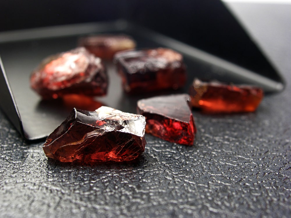 natural red garnet on gray background ready for gemstone cutting