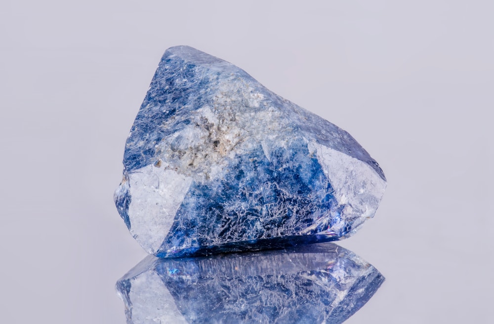 one of the rarest types of gem - image of a benitoite crystal on a white background