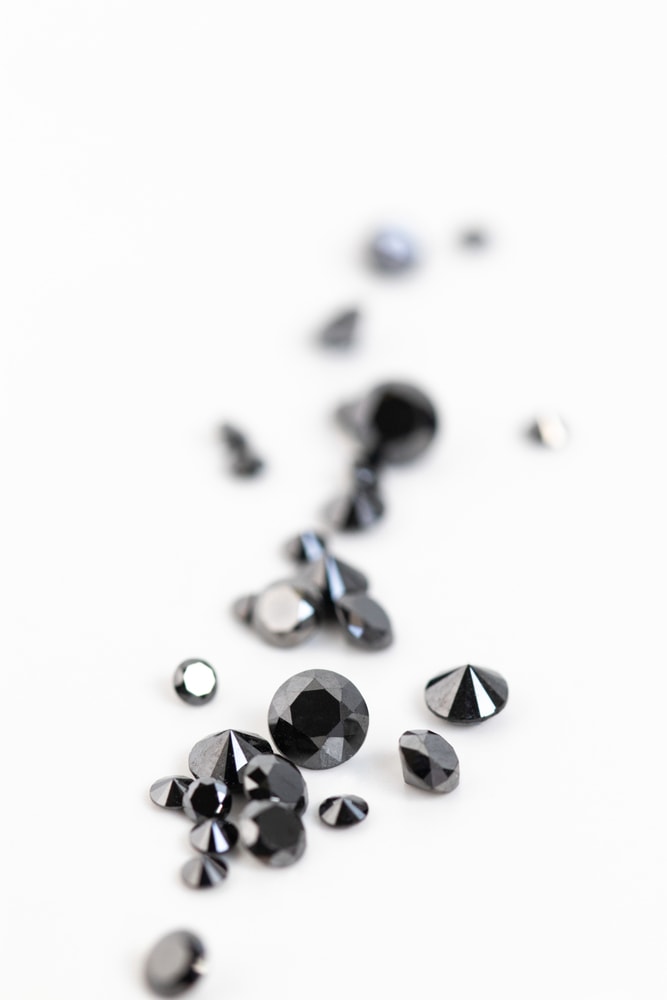 treated and cut black diamond gems on white background