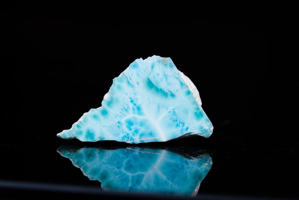 one of the rarest types of gem - larimar stone on a black background showing a white-sky blue hue