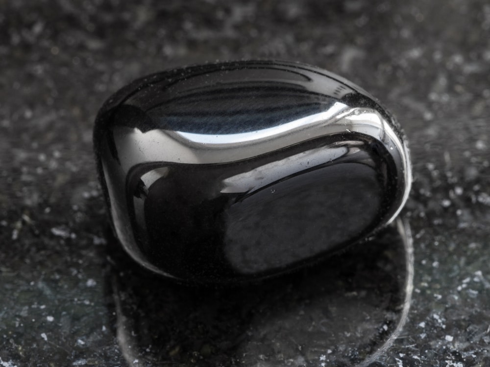 macro shot of a polished black onyx on a granite background