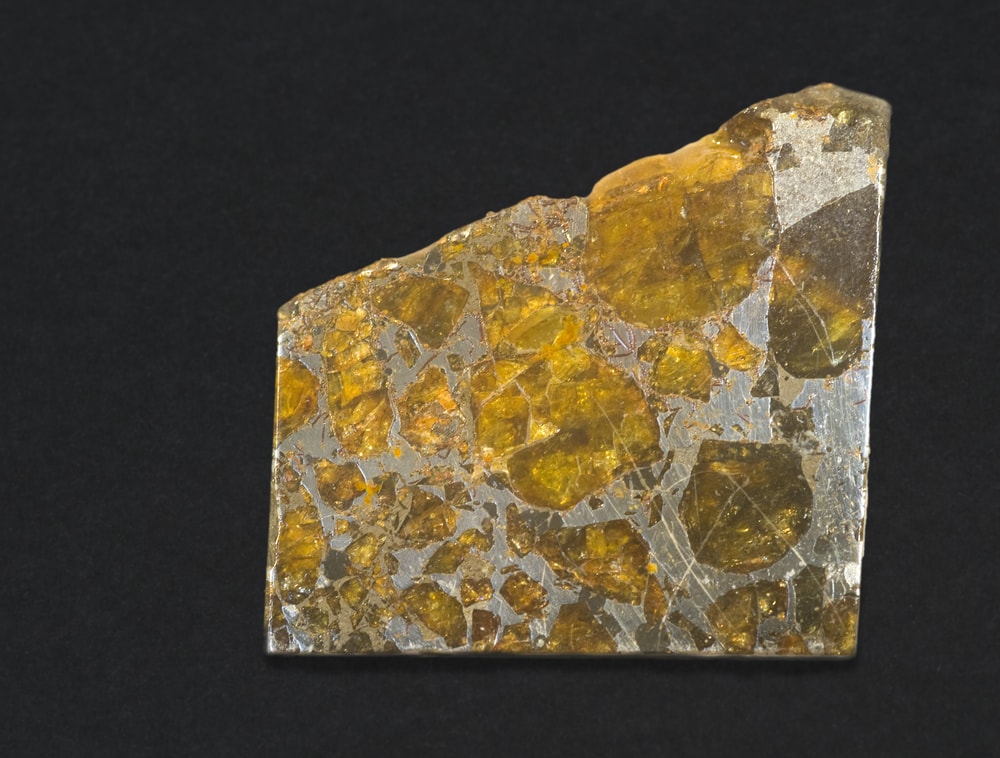 a polished slice part of the Pallasite Meteorite isolated on a black background