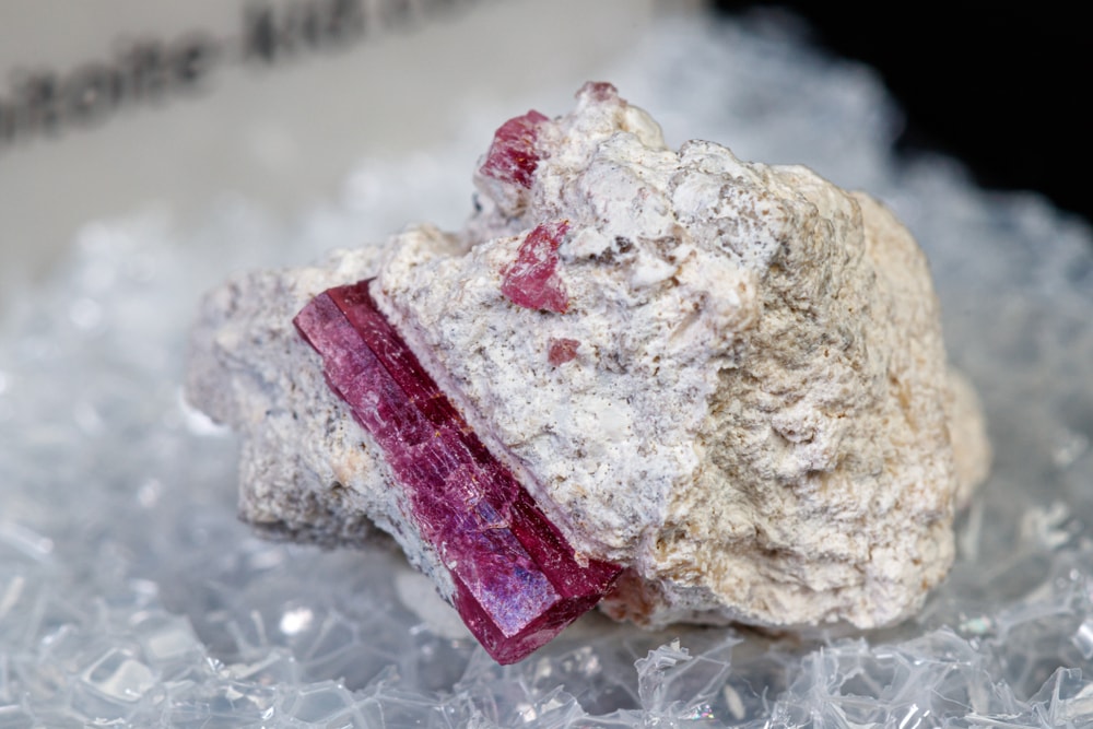 macro shot image of a red beryl crystal attached on a rock