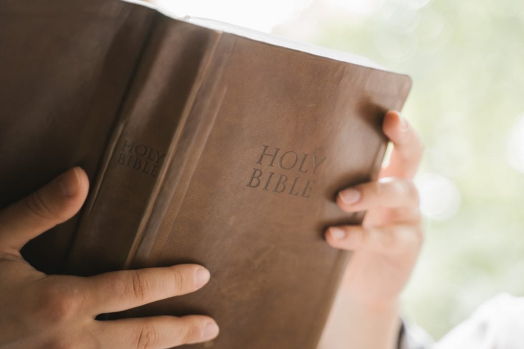 a man holding and reading a bible