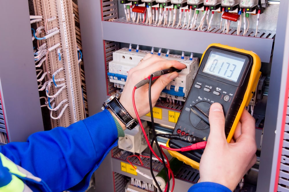an  electrician measures voltage by tester