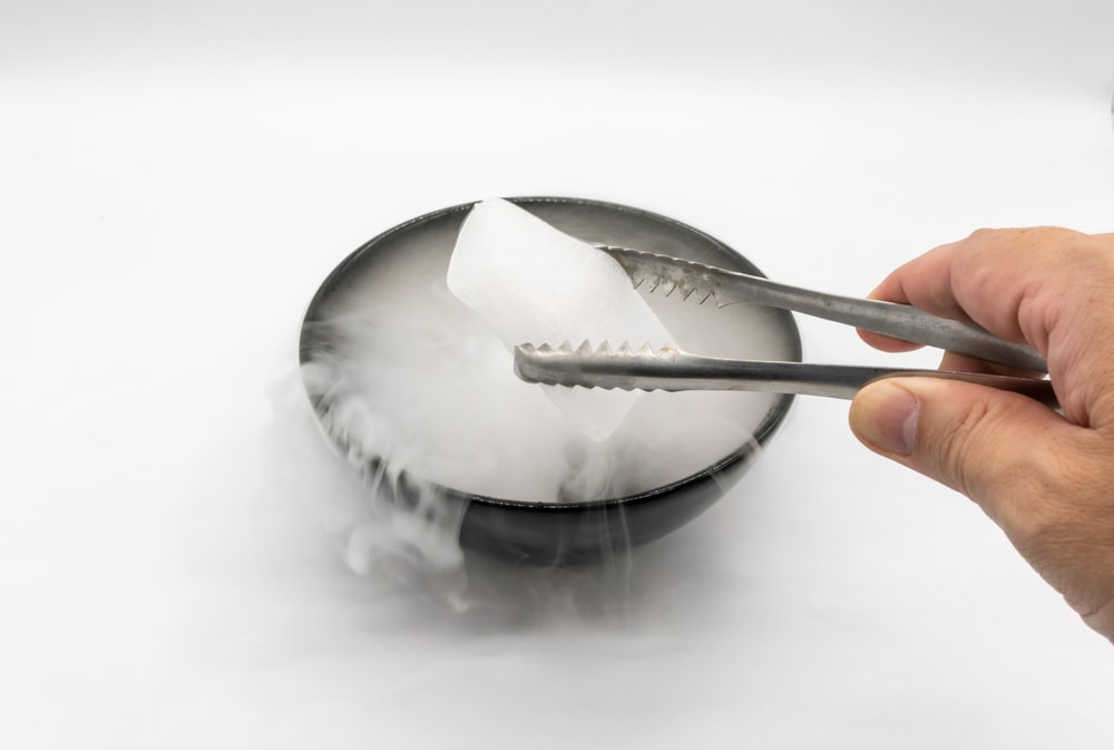 Dry ice being held on a tweezer