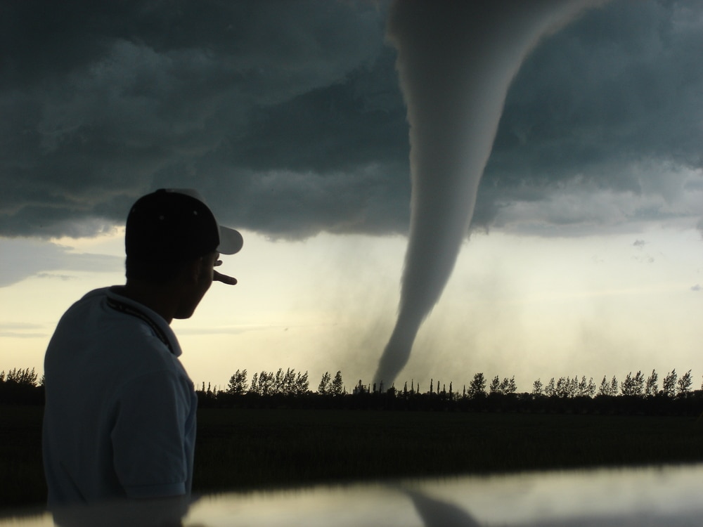 image of a man watching a tornado pass by