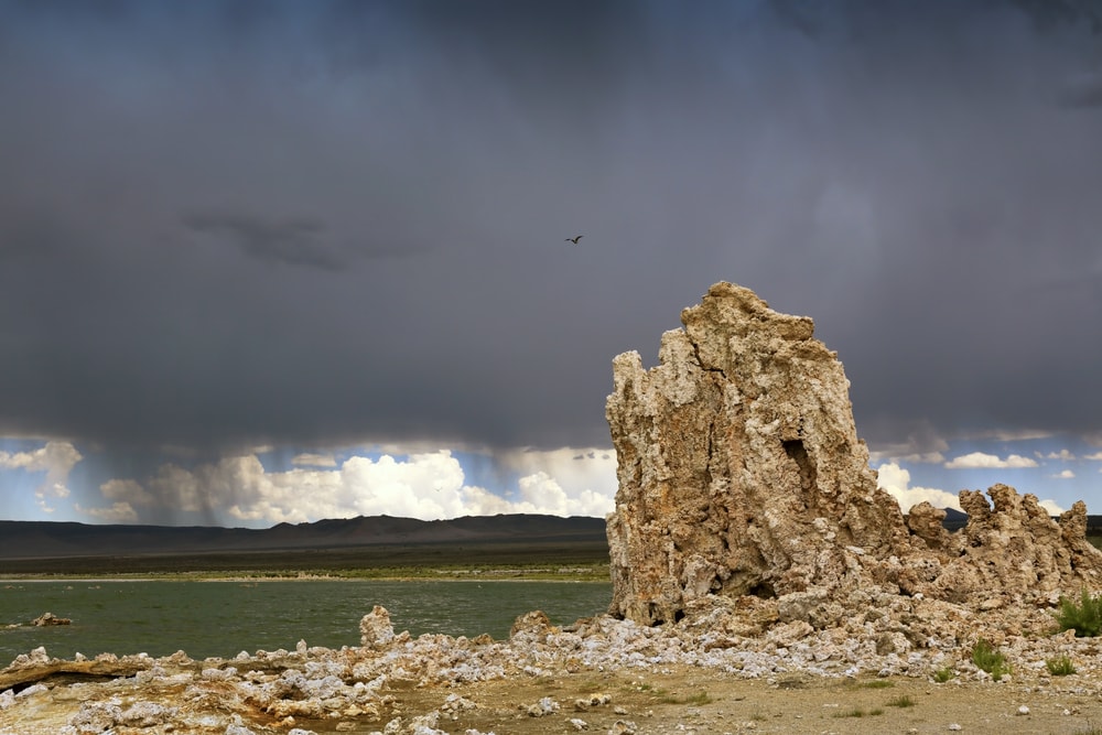 Huge dark virga clouds visible behind a stone