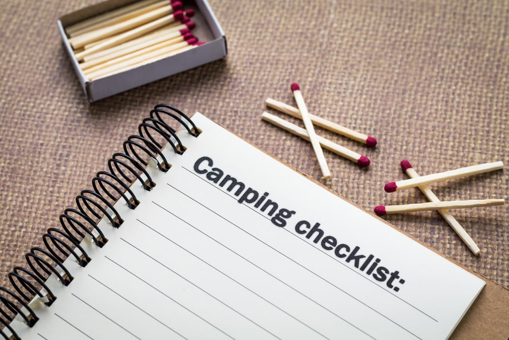 notebook with camping checklist and matches