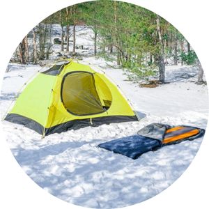 a tent and a sleeping bag on a snow 