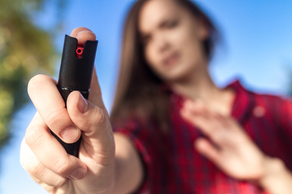a woman holding a pepper spray 