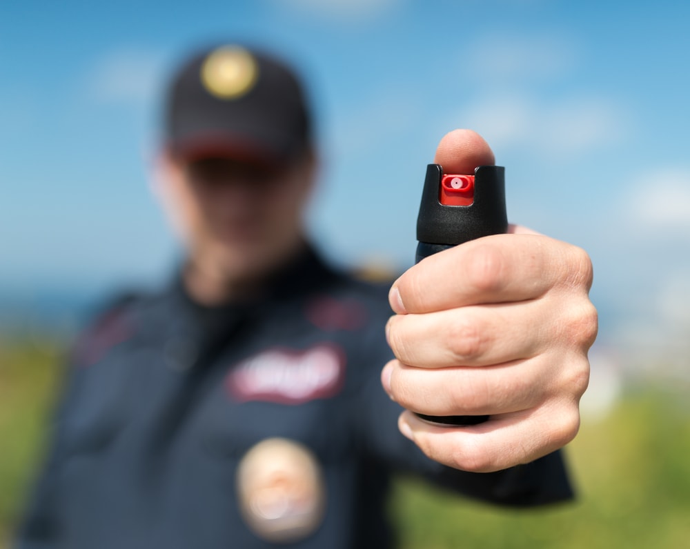 image of a policeman holding a pepper spray