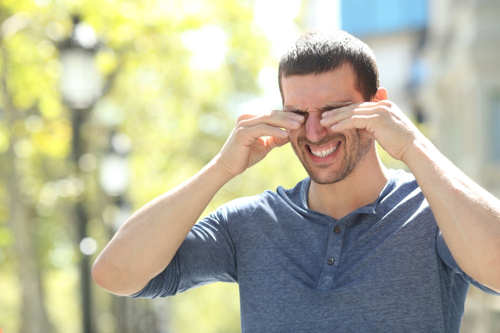 image of a man scratching his eyes