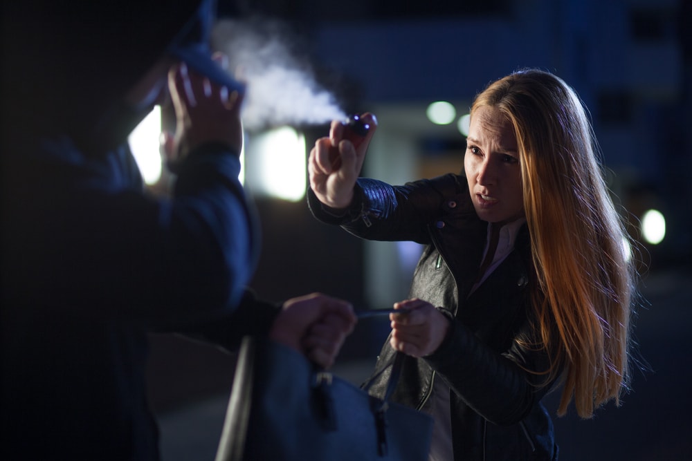 a woman using pepper spray for self defense 