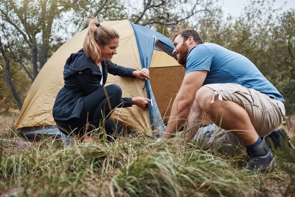 a couple setting up their tent