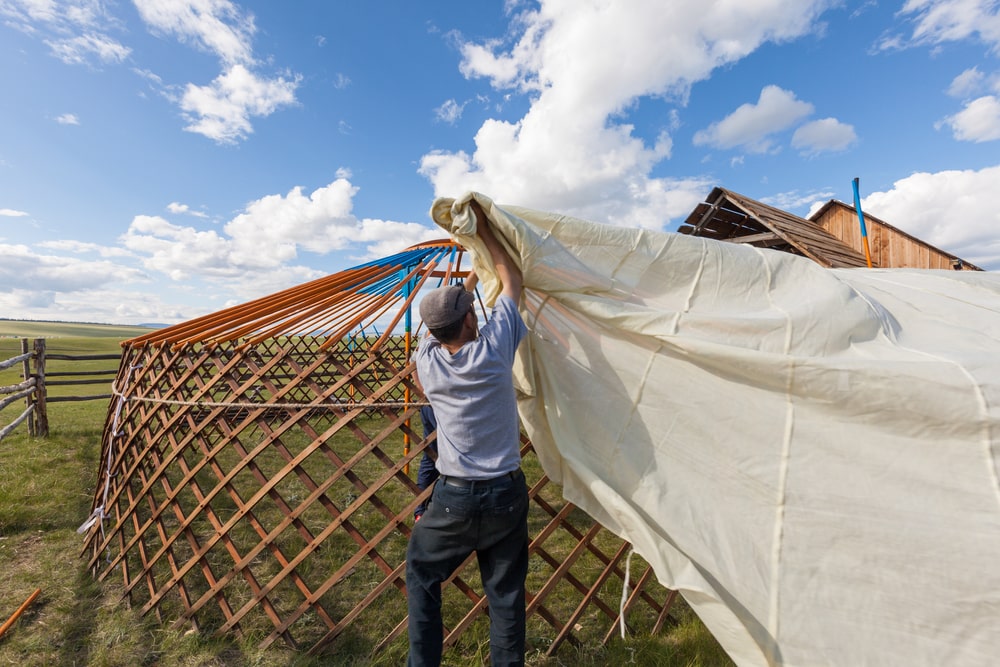 Man building a yurt in the fields