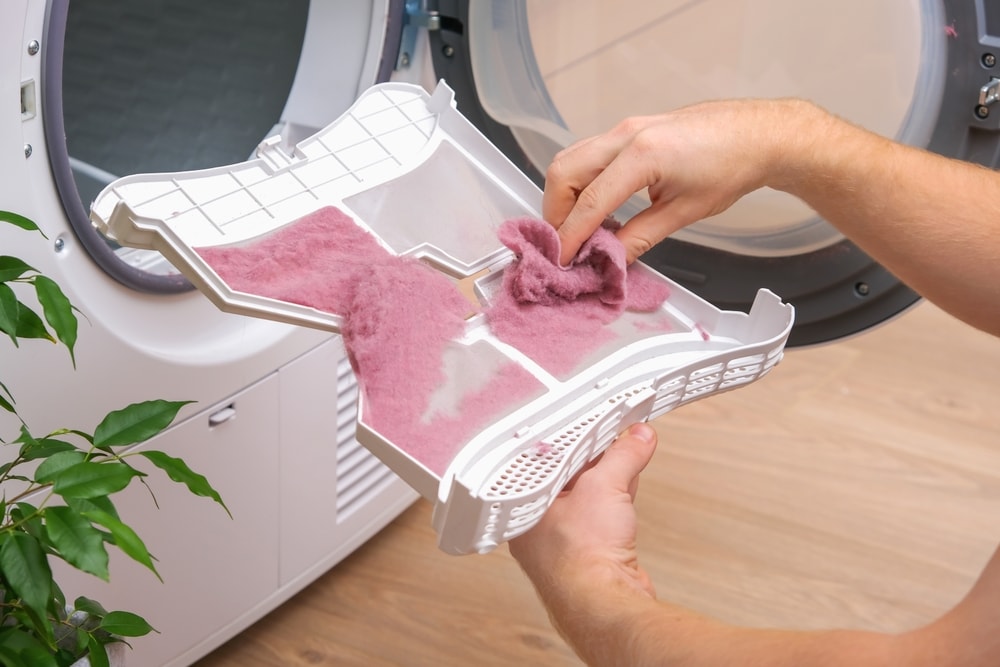 Washing machine lint being collected using a cloth