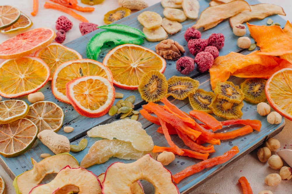 mixed dried fruits and vegetables on a blue wooden boad