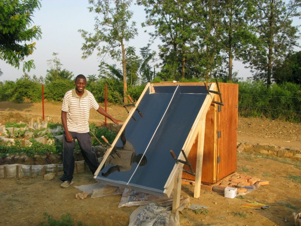 image of a man standing beside a DIY solar dehydrator